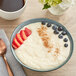A bowl of Cream of Wheat hot cereal with strawberries and blueberries.