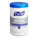 A white Purell container with a blue lid and a label reading "Purell Surface Disinfecting Wipes" 