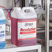 Two cases of Noble Chemical Resolution concentrated liquid detergent on a metal shelf.