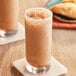 A close-up of two glasses of brown Big Train Spiced Chai Tea Latte.