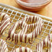 Pretzels with Alpine dark chocolate drizzled on top of them on a cooling rack.