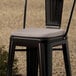 A Lancaster Table & Seating black metal chair with a grey cushion.