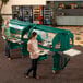 Two women standing in front of a green Cambro Versa food and salad bar.