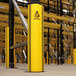 A yellow A-Safe RackGuard on a warehouse shelf pole.