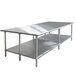 A long metal Advance Tabco stainless steel work table with a galvanized undershelf.