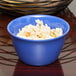 A stack of ocean blue Carlisle bouillon cups filled with coleslaw on a table.