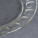 A clear glass Arcoroc dessert plate with a circular design.