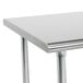 An Advance Tabco stainless steel work table with an open metal base.