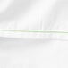 A white Monarch Brands flat sheet with green stitching.