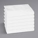 A stack of white folded Monarch Brands hotel sheets.