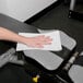 A hand on a white Chicopee Chix sports towel on a gym bench.