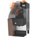 A Zummo Nature Compact Brown commercial orange juicer with oranges in it.