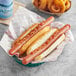 A basket of Nathan's Famous hot dogs with ketchup and mustard on them.