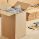 A Lavex kraft cardboard shipping box full of plastic bags.