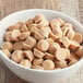 A bowl of Gertrude Hawk Mini Caramel Cups with caramel filling on a wood surface.