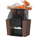 A Zummo Nature Brown commercial juicer with oranges on top.