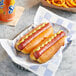 Nathan's Famous beef hot dogs with mustard and ketchup in a basket.