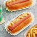 Two Nathan's Famous beef hot dogs with mustard on a white plate.