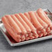 A tray of Nathan's Famous beef hot dogs on a metal surface.