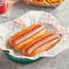 A basket of Nathan's Famous beef hot dogs with fries and a drink on a table in a stadium concession stand.