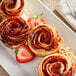 A white plate with four fresh red delicious apples.