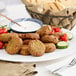 A plate of falafel with cucumber and tomatoes.