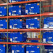 A green Vestil pallet racking frame with large blue boxes on the shelves.