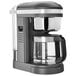 A KitchenAid gray coffee maker with a glass pot and black base.