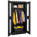 A black Hallowell metal wardrobe cabinet with Safety-View doors filled with clothes.