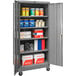 A gray Hallowell mobile storage cabinet with shelves and solid doors full of products.