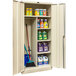 A tan Hallowell combination cabinet with shelves of cleaning supplies and solid doors.