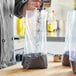 A chef pouring black rice into a Choice plastic food bag.