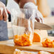 A person cutting a pumpkin in a Choice plastic bag.