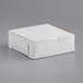A white bakery box with a window on a gray surface.