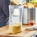 A person holding a Choice heavy-duty plastic food bag filled with corn on a counter.