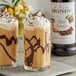 Two glasses of chocolate milk with whipped cream and Monin Dark Chocolate Syrup.