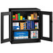 A black Tennsco storage cabinet with C-Thru doors storing boxes.