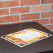A Menu Solutions brushed aluminum menu board on a table.
