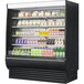 A black Turbo Air vertical refrigerator with drinks and beverages.