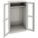 A light gray metal Tennsco wardrobe cabinet with open doors.