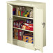 A putty Tennsco storage cabinet with shelves full of food and other items.