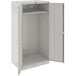 A light gray metal Tennsco wardrobe cabinet with open doors.