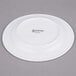 A white porcelain side plate with black Arcoroc text.