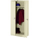 A putty metal Tennsco wardrobe cabinet with solid doors open to show a red shirt hanging inside.