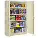 A Tennsco putty industrial storage cabinet with many items on the shelves.