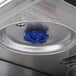 The blue valve on a silver surface of a Bunn Axiom coffee brewer.