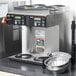 A Bunn commercial coffee maker on a counter with silver bowls and trays.