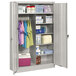 A light gray Tennsco metal cabinet with items on the shelves.