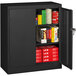 A black metal Tennsco storage cabinet with solid doors and shelves full of books and other items.