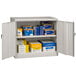 A light gray metal Tennsco storage cabinet with solid doors.